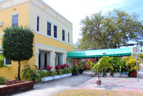 a yellow building with a sign that reads truth on time at The Inn On Third in St. Petersburg