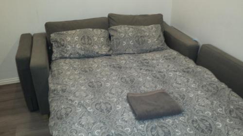 a bed with a blanket and two pillows at Glasgow Hampden Garden Flat in Glasgow