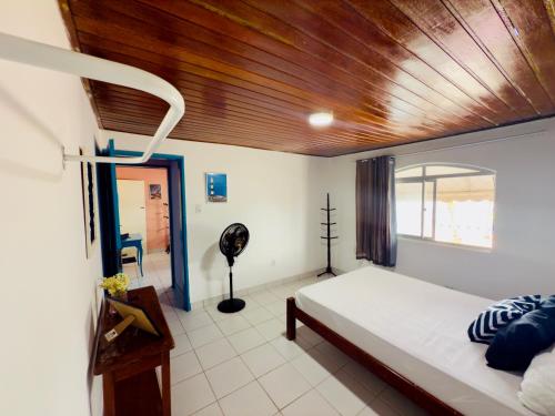 a bedroom with a bed and a wooden ceiling at Guest House Rosa do Mar in Olinda