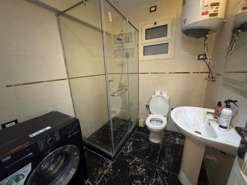 a bathroom with a shower and a toilet and a sink at Rehab Modern Apartment in New cairo
