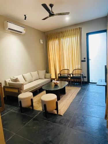 a living room with a couch and a table and chairs at The Bali House in Bhopal