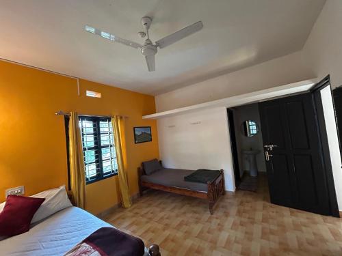 a bedroom with yellow walls and a bed and a window at Mountain View Villas in Madikeri