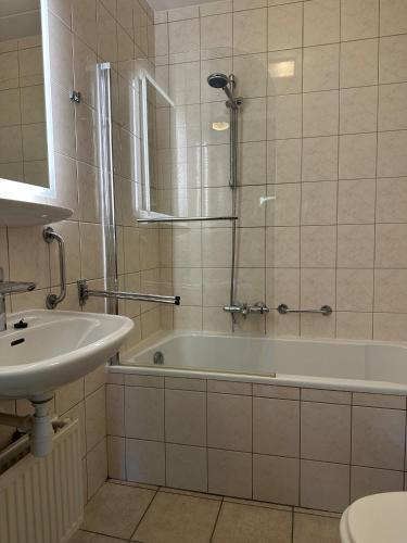 a bathroom with a bath tub and a sink at Recreatiebungalow Lochem in Lochem
