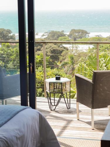 a bedroom with a bed and a table and a chair at Ocean Vista Boutique Guest House in Durban