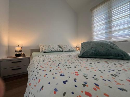 a bedroom with a bed with a comforter and a window at Casa del Sole Lux in Kotor