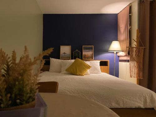 a bedroom with a large white bed with a blue wall at Cozy 1br walk to BTS and Airport Rail Link Close to Malls m11 in Bangkok