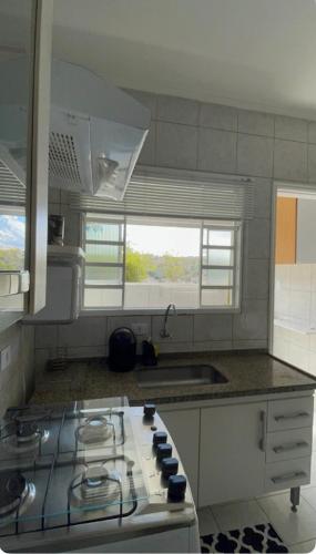 a kitchen with a stove top and a sink at Apartamento Vista da Serra in Poços de Caldas