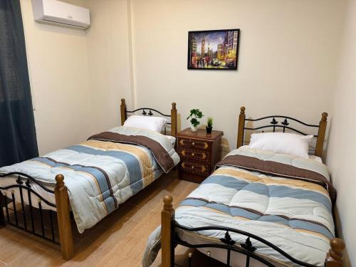 two beds sitting next to each other in a room at Chic Modern Apartment - New Cairo in New cairo