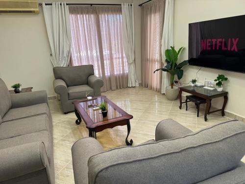 a living room with two couches and a table at Chic Modern Apartment - New Cairo in New cairo