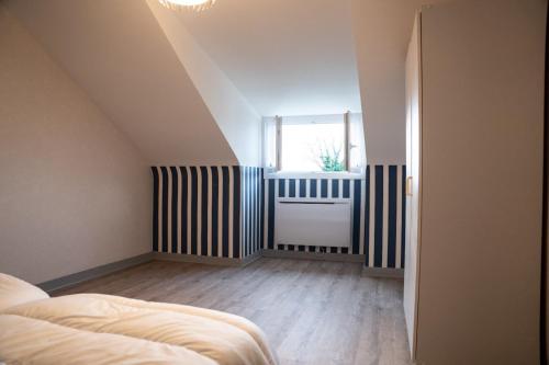 Cette chambre mansardée comprend un lit et une fenêtre. dans l'établissement Ti Marie Thérèse, à Fouesnant