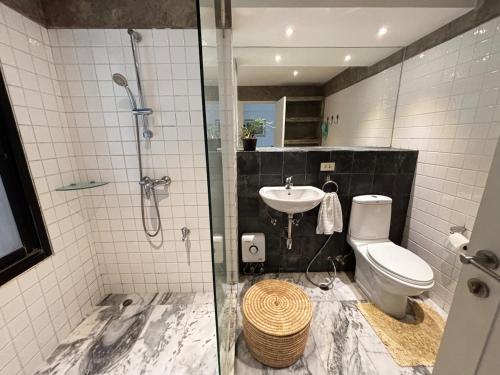 a bathroom with a shower and a toilet and a sink at Rare, Special Beach Pool Villa in Hua Hin