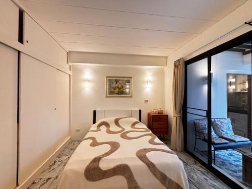 a small bedroom with a bed and a window at Rare, Special Beach Pool Villa in Hua Hin