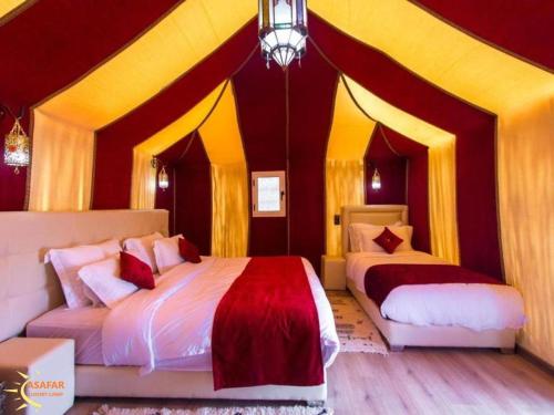 a bedroom with two beds in a circus tent at Asafar Luxury Camp in Merdani