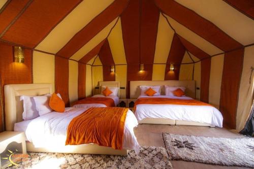 a room with two beds in a tent at Asafar Luxury Camp in Merdani