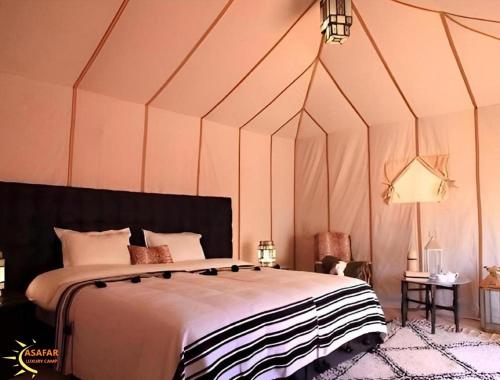 a bedroom with a large bed in a tent at Asafar Luxury Camp in Merdani