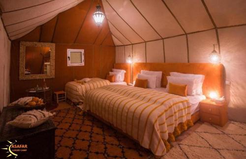 a bedroom with two beds in a tent at Asafar Luxury Camp in Merdani