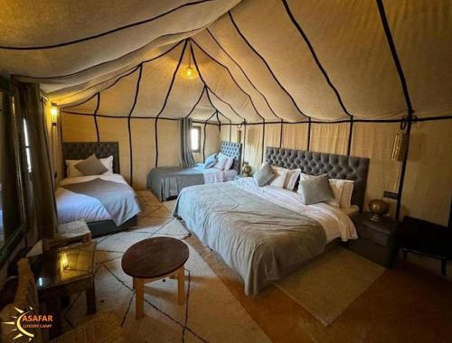 a bedroom with two beds in a tent at Asafar Luxury Camp in Merdani