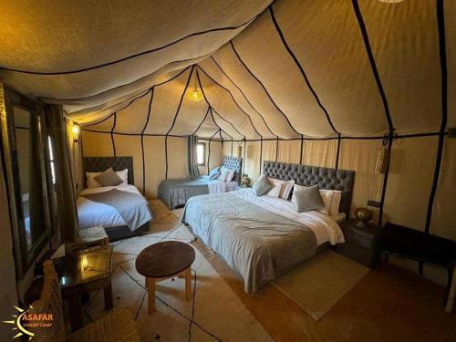 a bedroom with two beds in a tent at Asafar Luxury Camp in Merdani