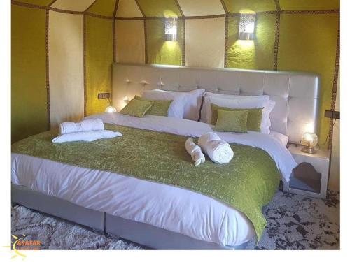 a large white bed with two pillows on it at Asafar Luxury Camp in Merdani