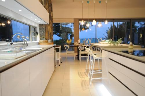 a kitchen with white cabinets and a dining room at Beachfront & Pool Poste Lafayette in Poste Lafayette