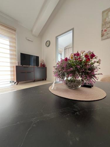 a vase of flowers sitting on a table in a living room at Casa del Sole Lux in Kotor