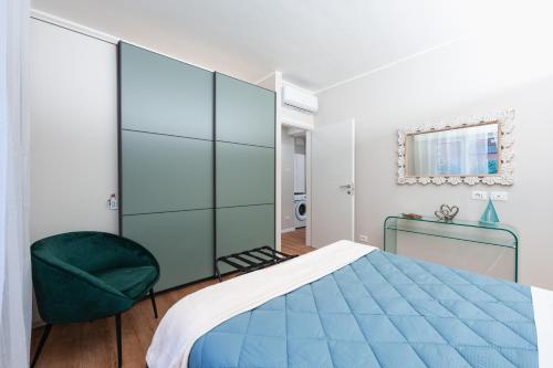 a bedroom with a blue bed and a green chair at BG Apartments - Central and quiet one-bedroom flat in Sestri Levante