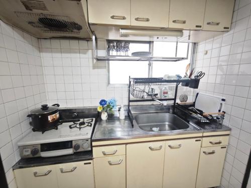 a kitchen with a sink and a stove at ZYZSumiyoshichō 2K in Tokyo