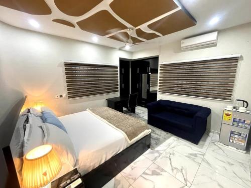 una camera da letto con un letto e un divano blu di Whispering Hearts Guest House a Botianaw