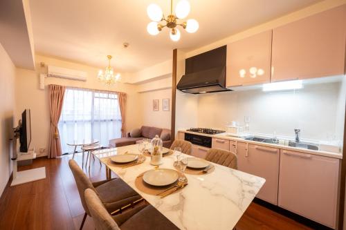 a kitchen and living room with a table and chairs at Ushamy's KOKURA STAY No 03 in Kitakyushu