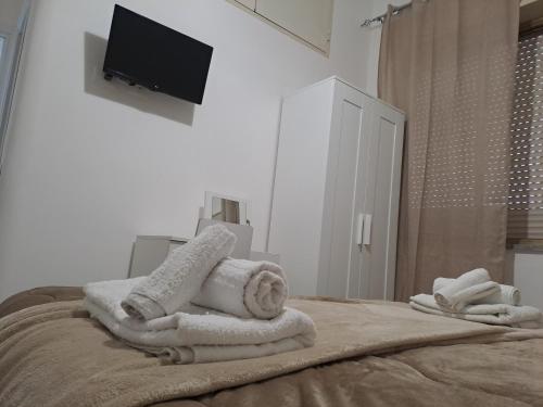 een slaapkamer met handdoeken en een televisie op een bed bij Bedroom la stazione in Palermo