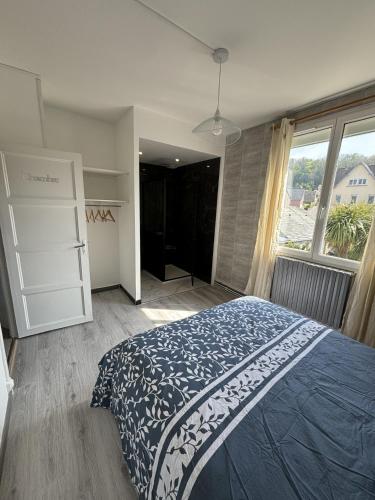 une chambre avec un lit et une grande fenêtre dans l'établissement les dunes proche plage jardin, à Urville-Nacqueville