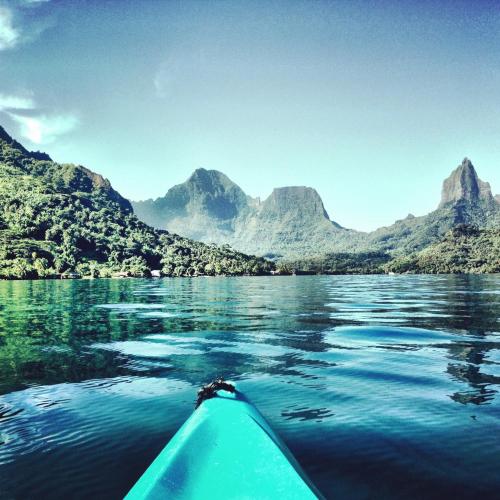 a kayak on a lake with mountains in the background at Robinson's Cove Villas in Papetoai