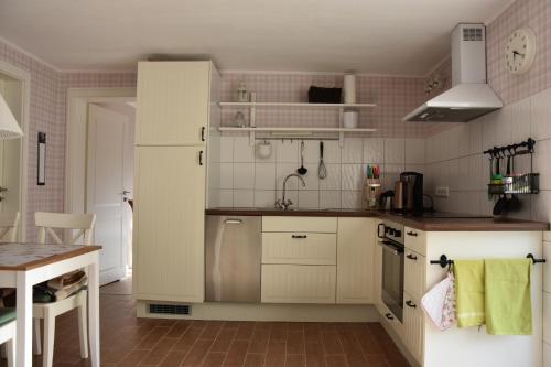 eine Küche mit einem weißen Kühlschrank und einem Tisch in der Unterkunft Bungalow Gartenzauber in Grube