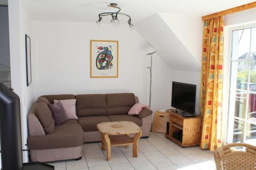 a living room with a couch and a tv at Ferienwohnung Sünnenkringel 58 in Zingst