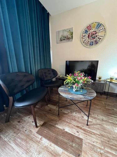 a room with two chairs and a table with flowers on it at Casa del Sole Lux in Kotor