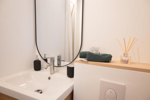 a bathroom with a sink and a mirror at Troyes - Aux pieds du cube in Troyes