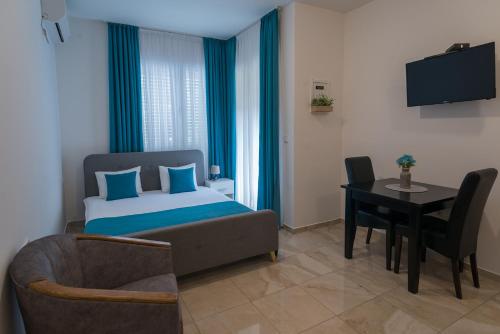 a bedroom with a bed and a table and a chair at Apartments Sunrise in Herceg-Novi