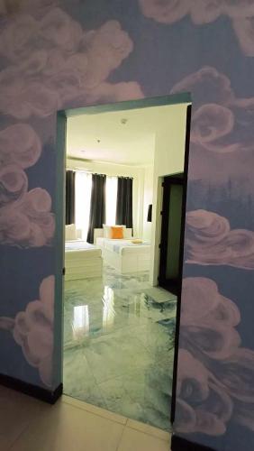 a mirror in a room with clouds painted on the wall at The ApplePeach House in Legazpi