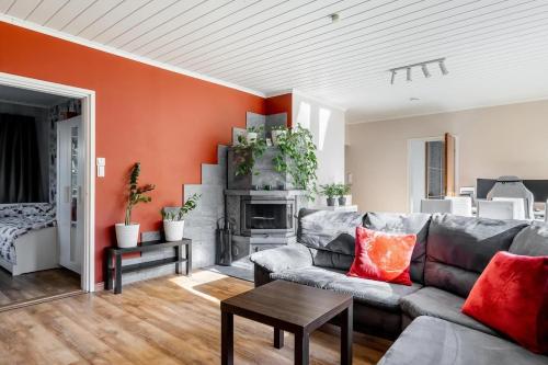 a living room with a gray couch and an orange wall at Ihana omakotitalo omalla pihalla in Turku