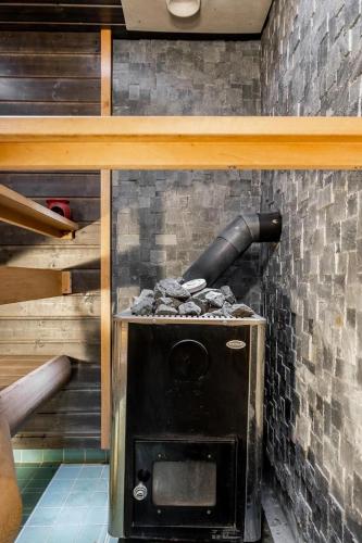 a black oven in a room with a brick wall at Ihana omakotitalo omalla pihalla in Turku