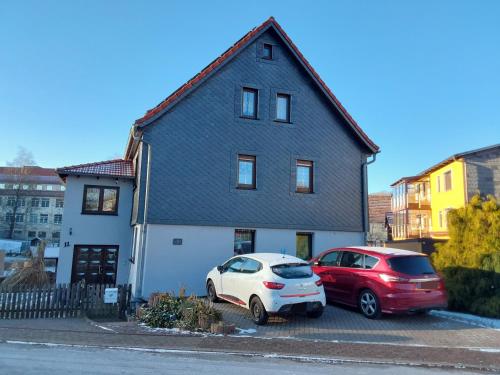 two cars parked in a parking lot in front of a house at Fewo Rosi in Brotterode-Trusetal