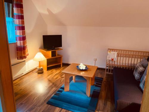 a living room with a table and a crib at Ferienwohnung mit großem Balkon in Feistritz im Rosental