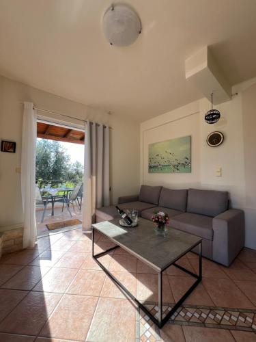ein Wohnzimmer mit Sofa und Tisch in der Unterkunft Olive Tree House I in Dhermatiánika