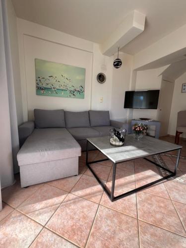 ein Wohnzimmer mit Sofa und Tisch in der Unterkunft Olive Tree House I in Dhermatiánika