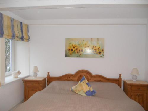 a bedroom with a bed and a painting on the wall at Nordlicht im Haus Kaya, Hafenstraße in Wyk auf Föhr