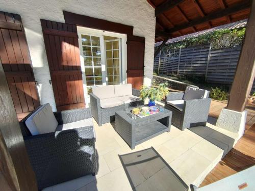d'une terrasse avec des chaises et une table. dans l'établissement Villa landaise lumineuse avec jardin, proche plages et commerces à Piraillan - FR-1-736-52, à Lège-Cap-Ferret