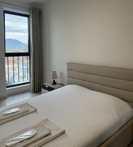 a bedroom with a bed and a large window at Tirana Hideaways, Free Parking & Breathtaking View in Tirana