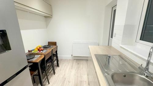 a kitchen with a sink and a table with chairs at Cozy 5-Bed Caldecott Stays-Sleep 6 in Manchester