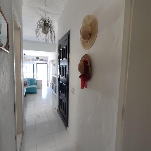 a hallway with a door and a hat on a wall at Vista Mar Sardina in Gáldar
