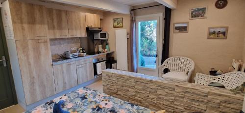 une cuisine avec un comptoir en pierre et des chaises à l'intérieur dans l'établissement Lou pichoun studio au coeur d'un village provençal, à Gargas